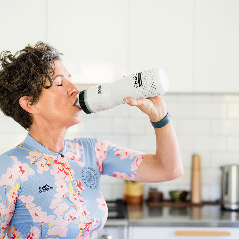 Woman drinking water in cycling gear during summer