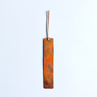 Copper bookmark with cream leather tassel.