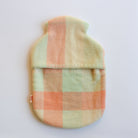 Plaid patterned hot water bottle cover on a white background