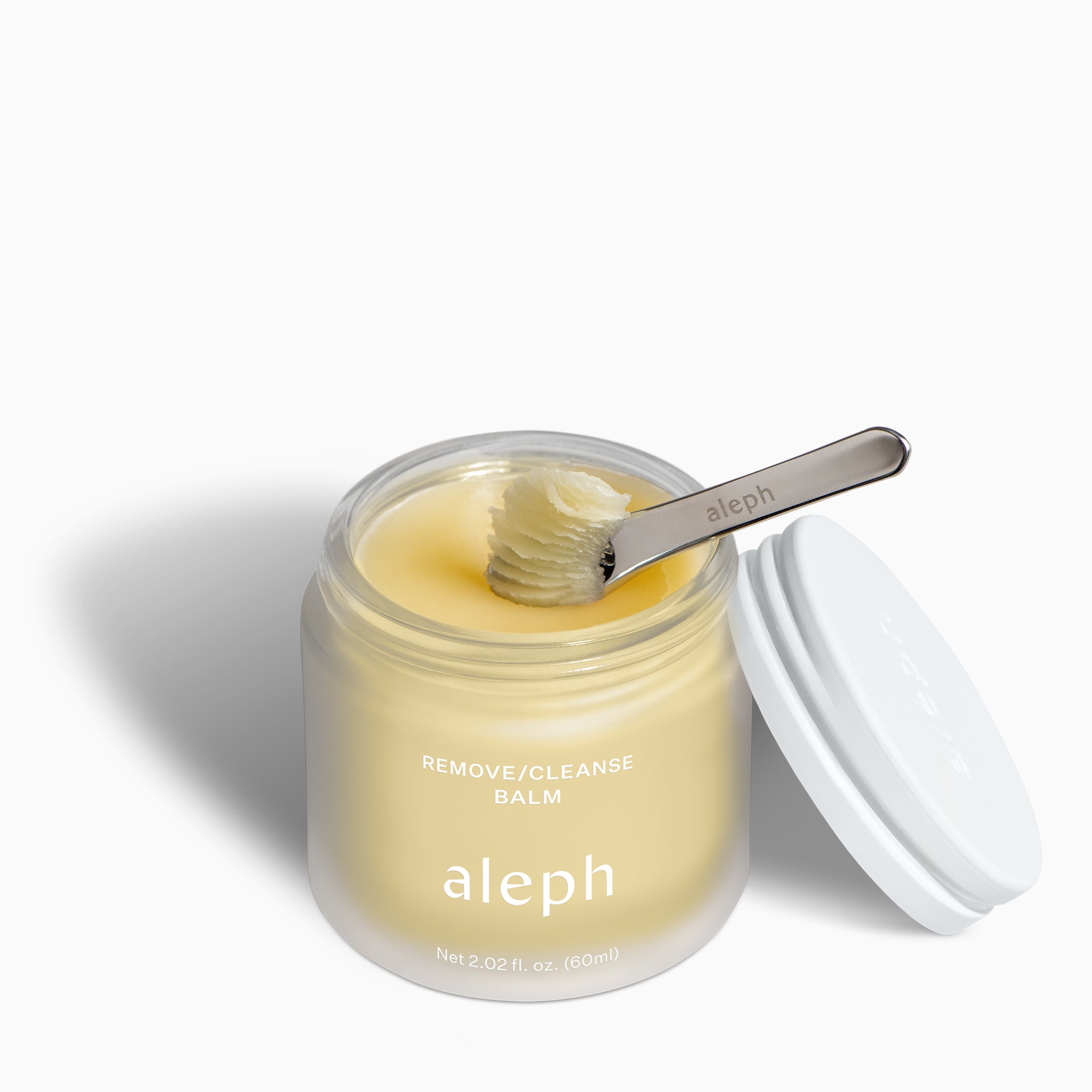 Jar of aleph Remove/Cleanse Balm with a spoon inside on a white background