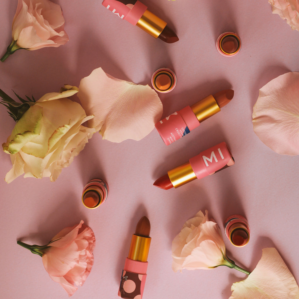 A selection of Hanami  lipsticks surrounded by roses and rose petals.