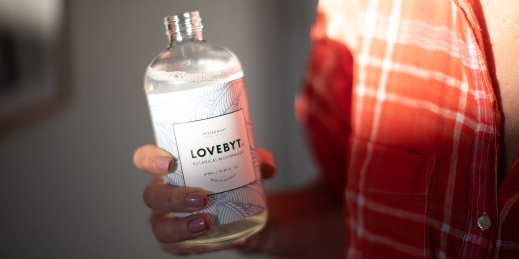 Amy holding a bottle of Lovebyt Mouth Wash. 