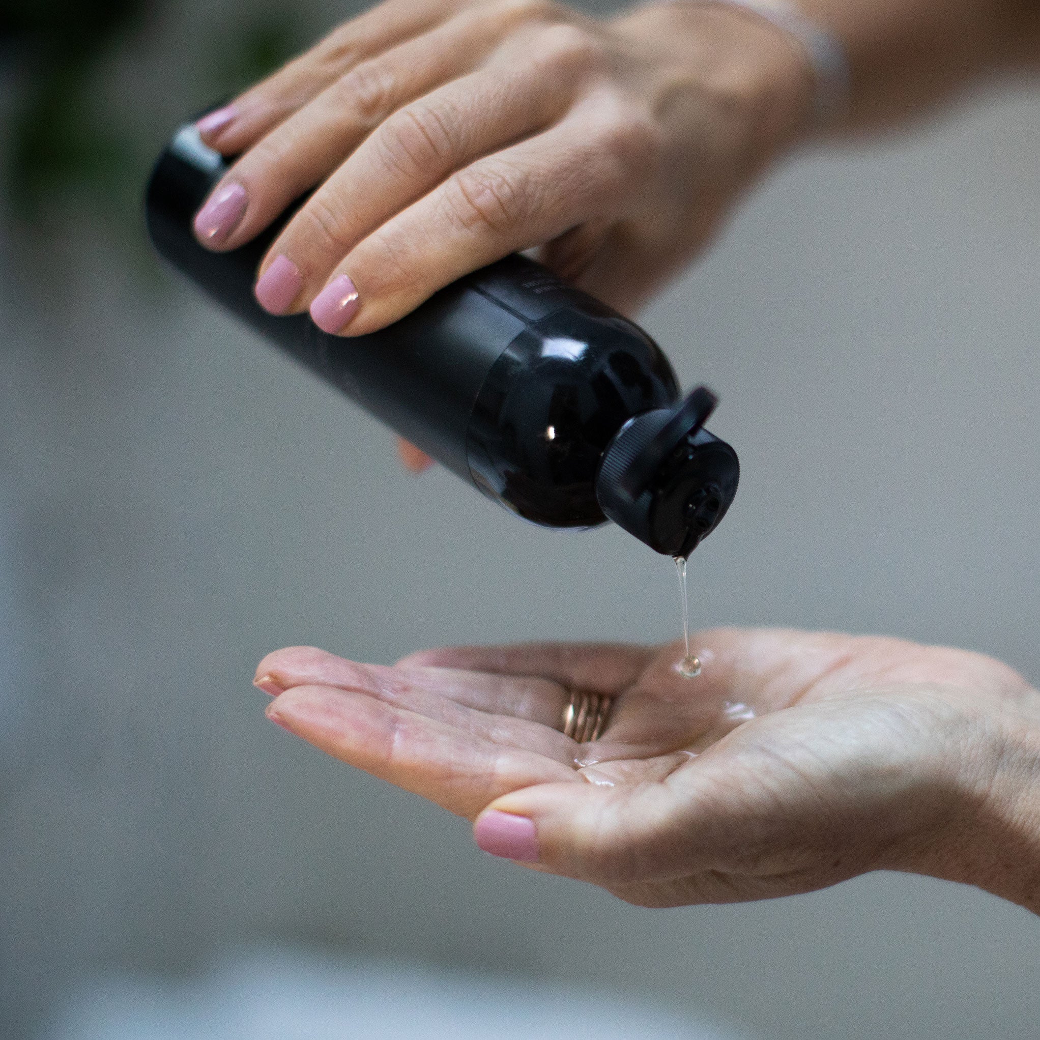 Amy pouring Denu Seductive Body Oil into her hand