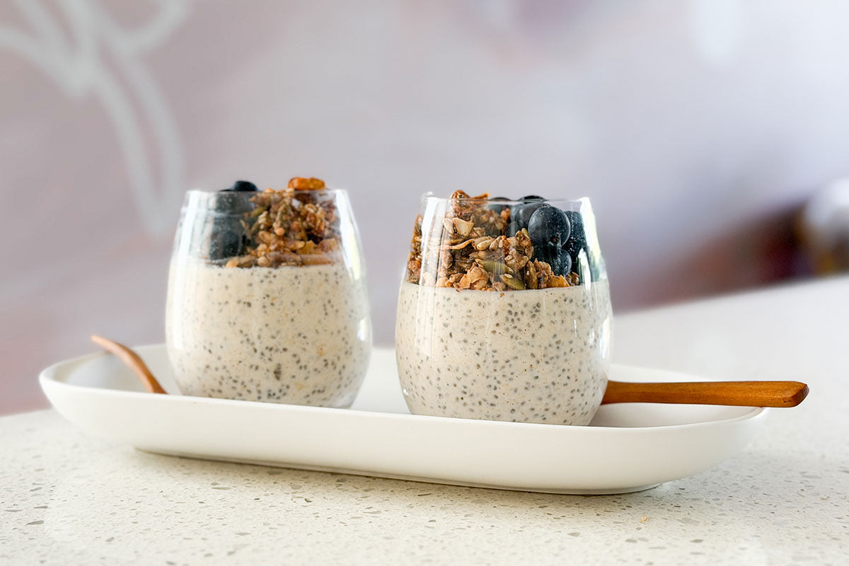 Maca Protein Overnight Chia Oats on kitchen bench with pouch of maca powder