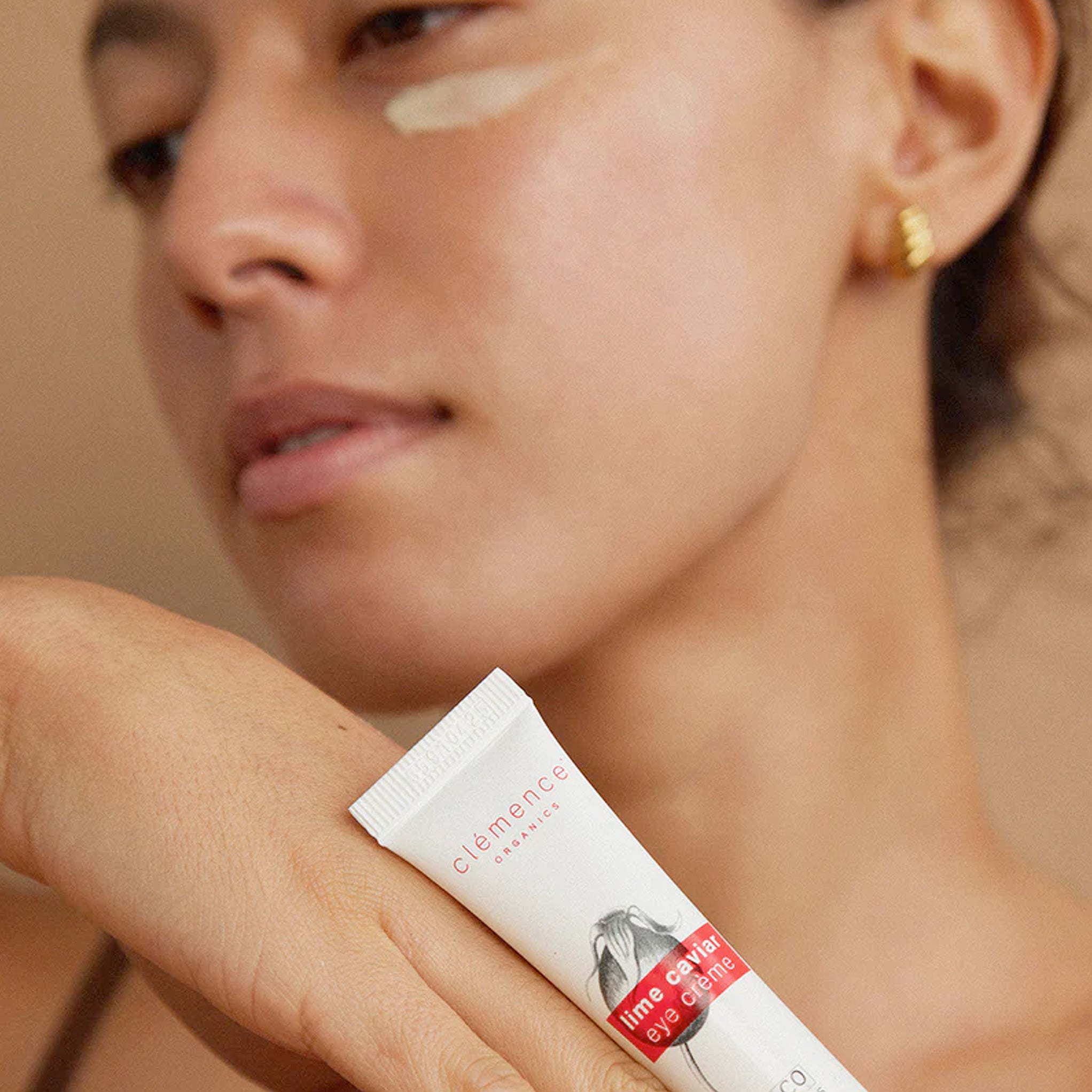 Woman holding a tube of Clémence Organics Lime Caviar Eye Crème