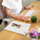 Amy drinking a glass of Daily Greens at her desk.