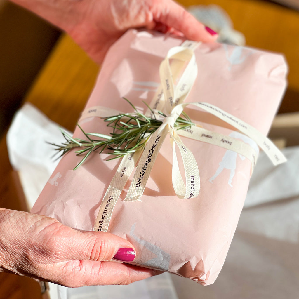 Amy holding a gift wrapped by The Holistic Ingredient. 