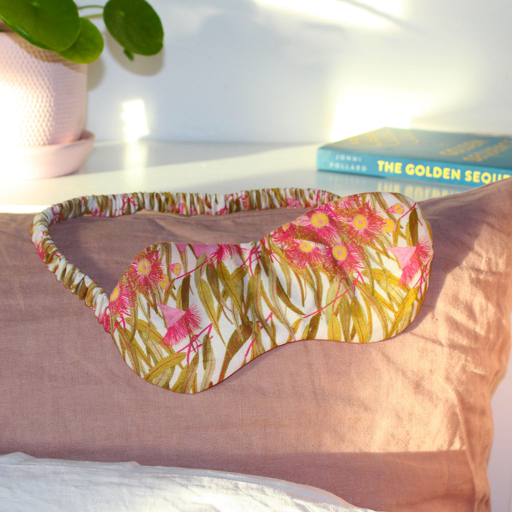 An eye mask made of pink flowering gum printed fabric. 