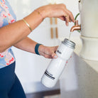 Amy filling a white water bottle with Daily Hydration Blend and water