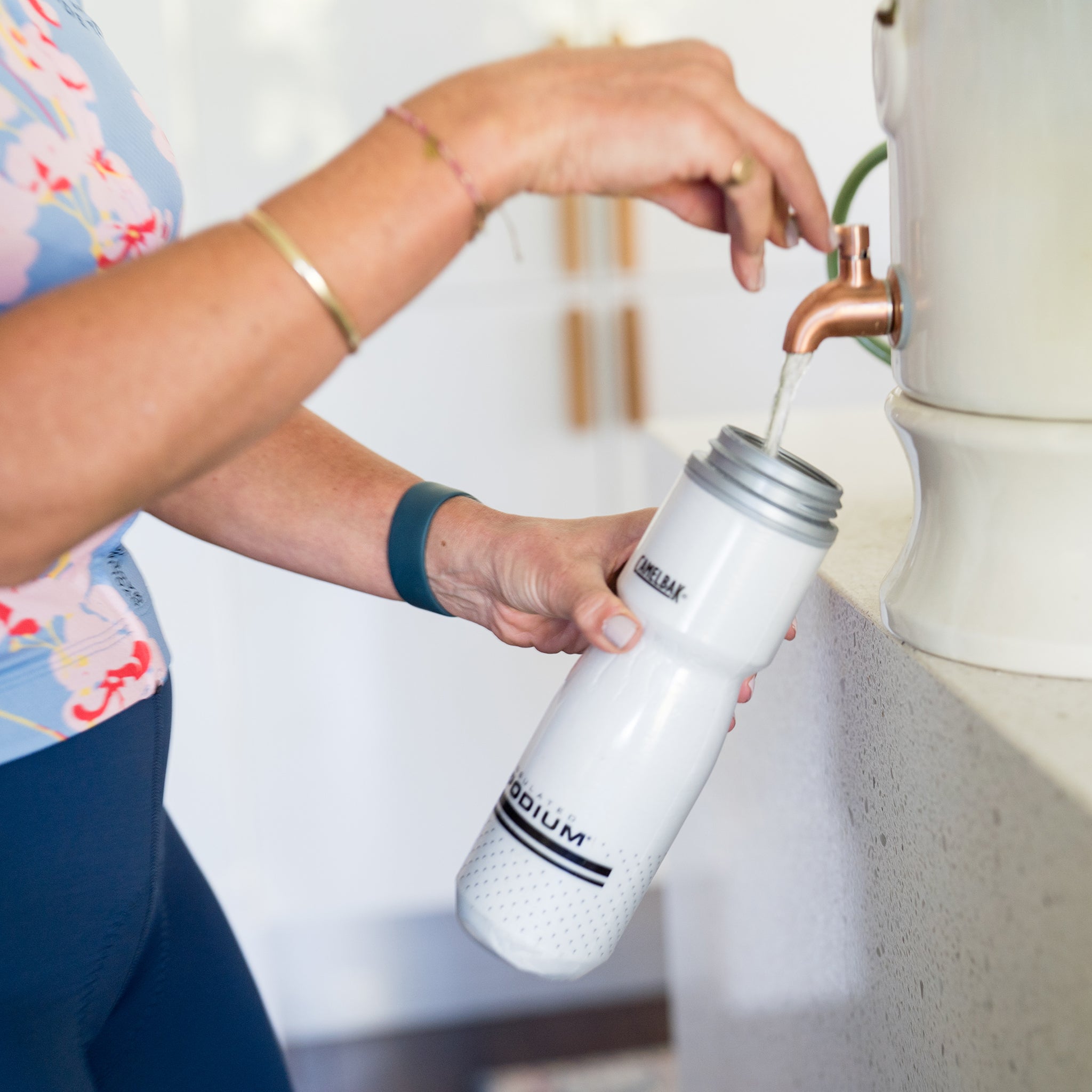 Amy filling a white water bottle with Daily Hydration Blend and water