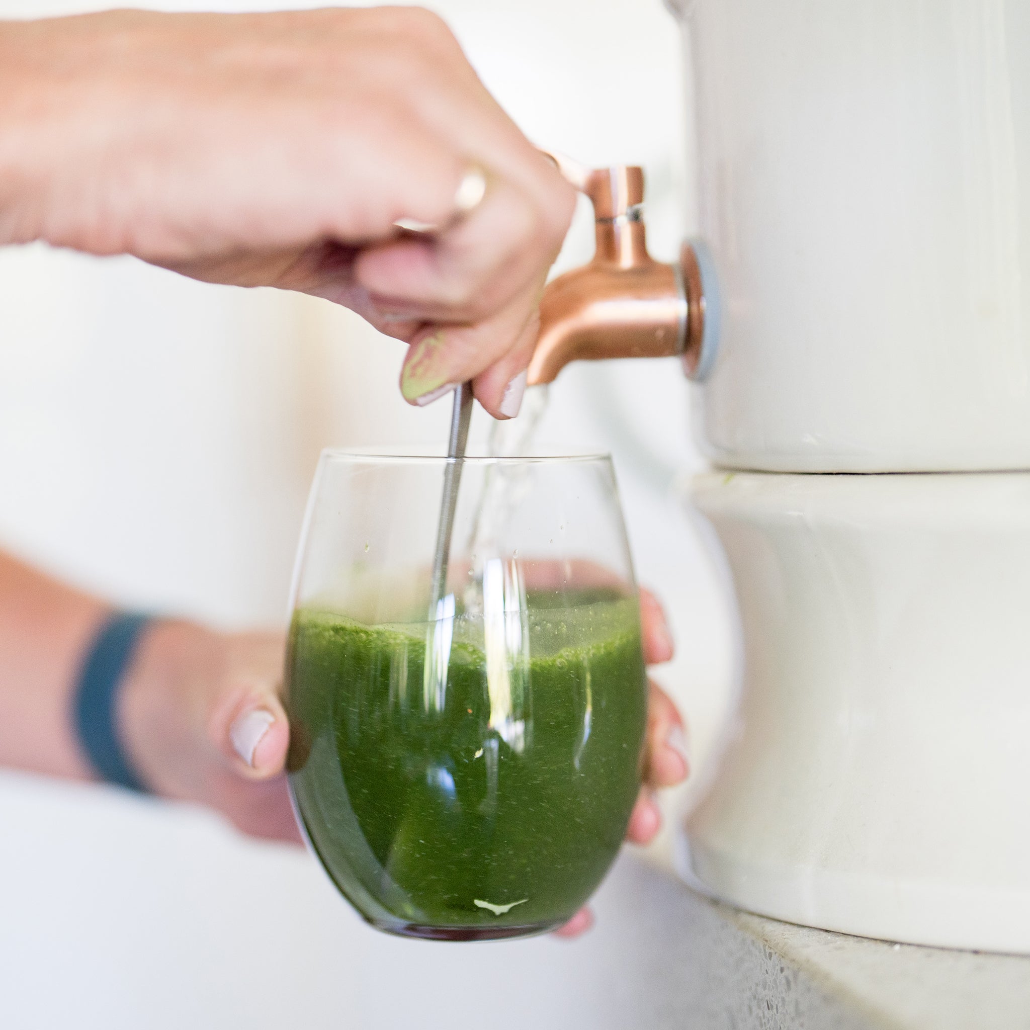 Amy filling a glass of Daily Greens with water