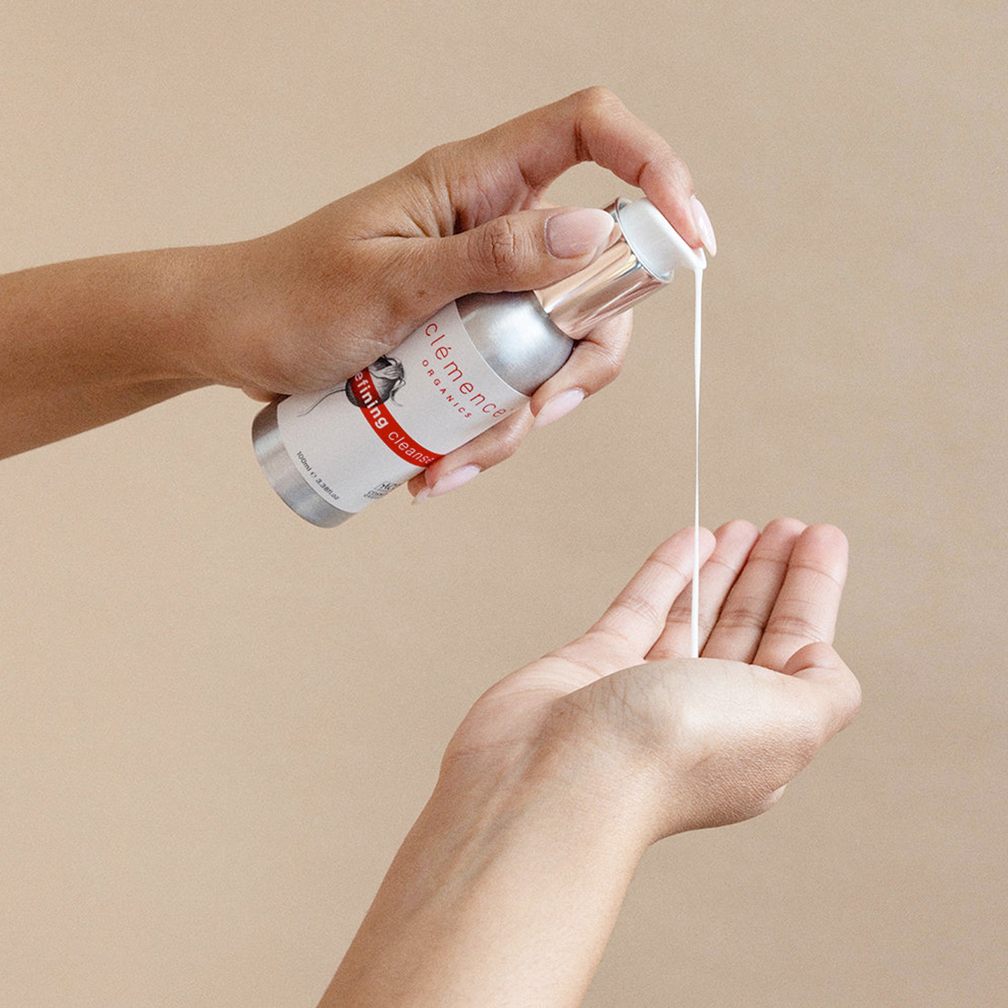 A person using Clémence Organics Refining Cleanser on their hand.