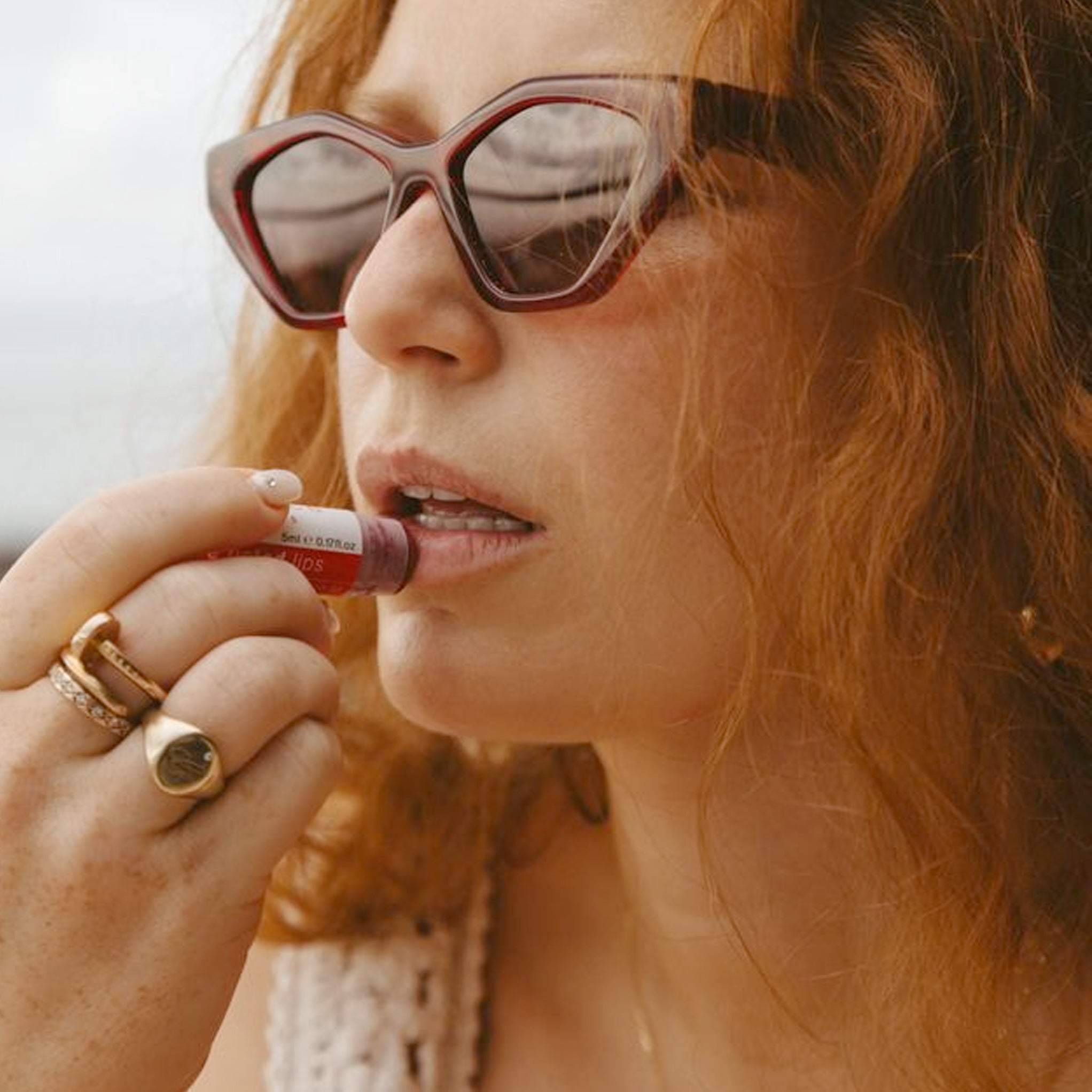 A woman applying Clémence Organics Rose Tinted Lips