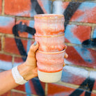 Amy holding a stack of Sonos Studio Ceramic Cups in sunset