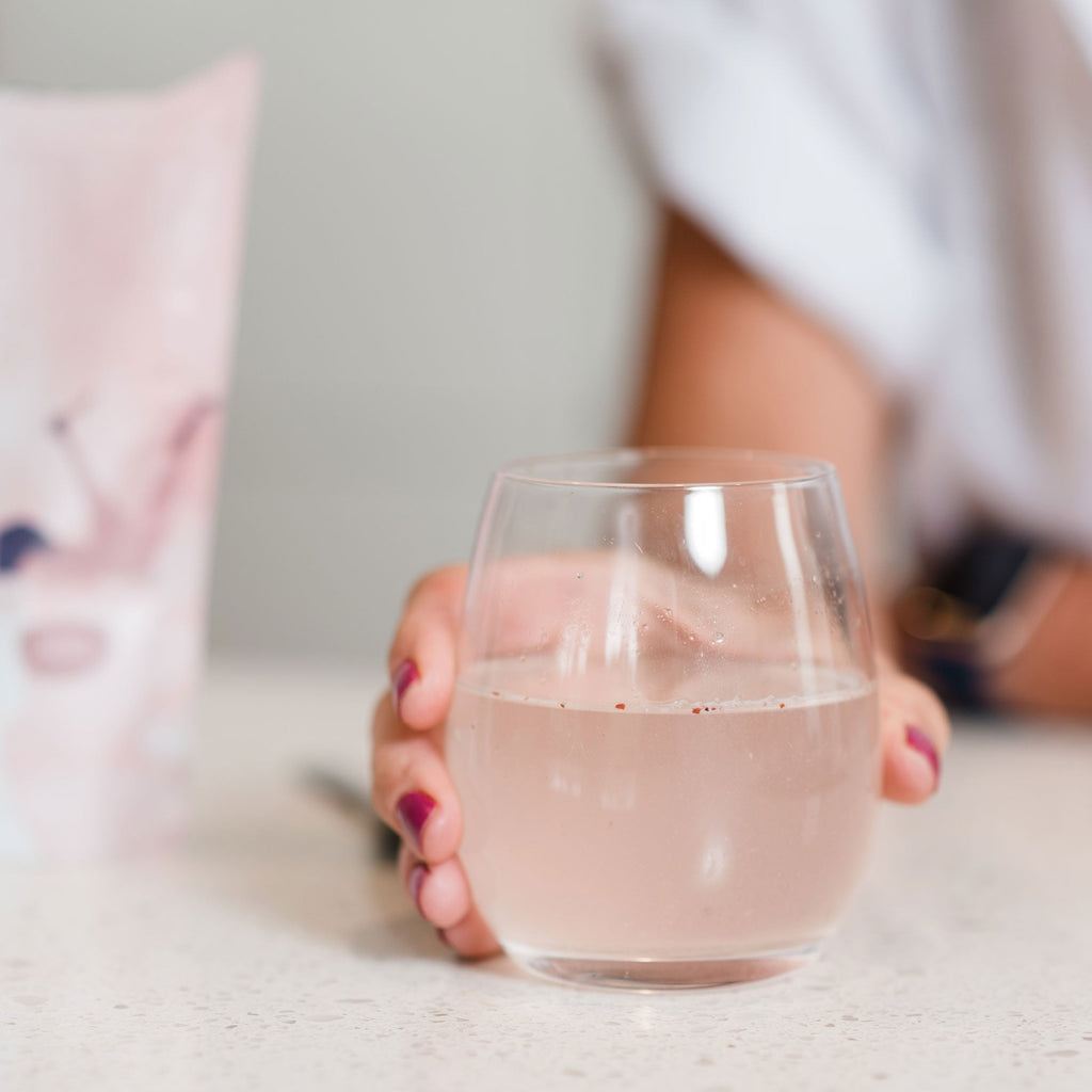 Amy drinking a glass of Marine Collagen with Australian Kakadu and Davidson Plum dissolved in water