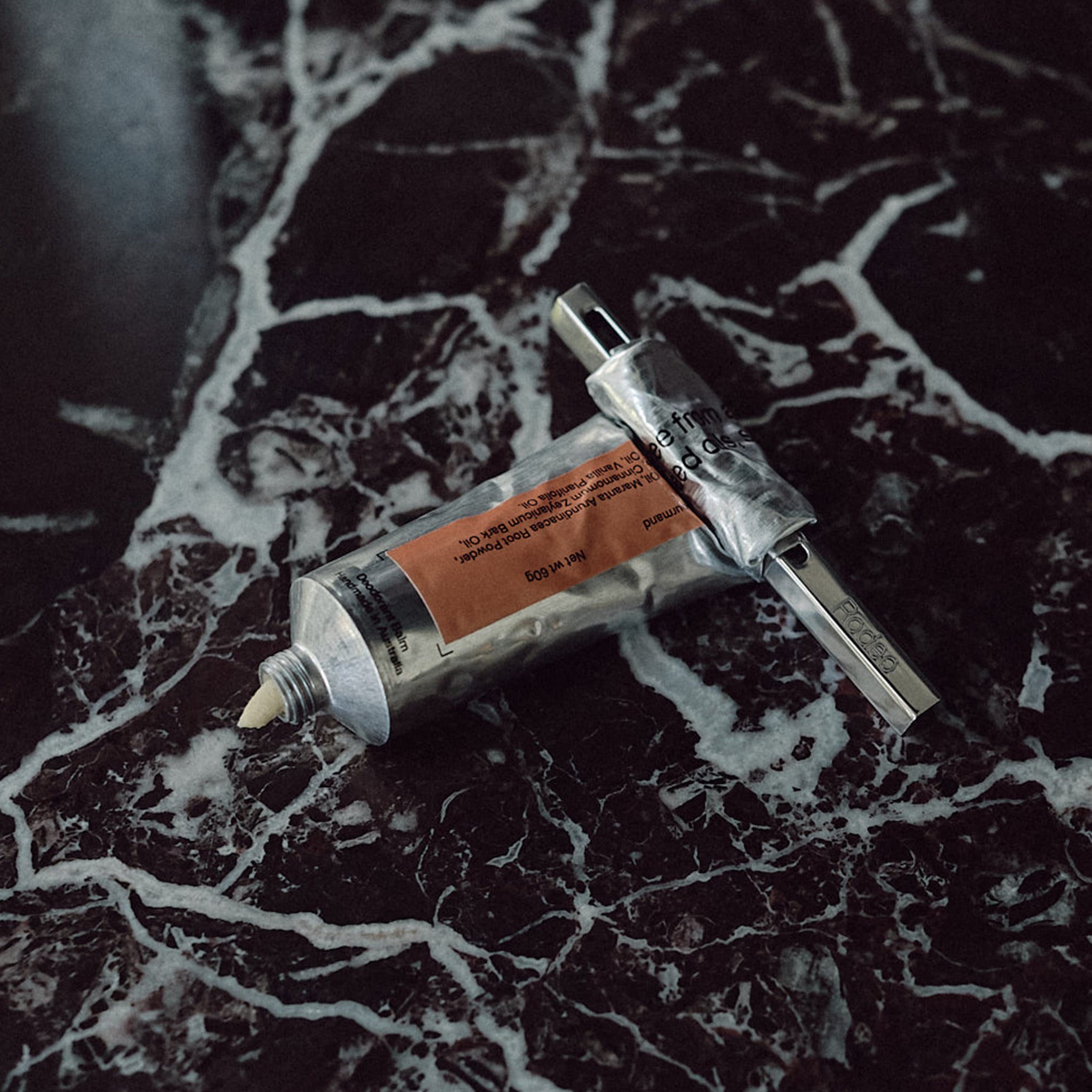 Two tubes of deodorant on a marble surface