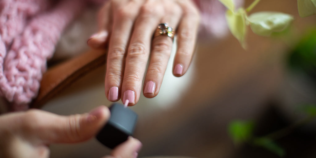 Amy Crawford painting her nails with pink Hanami nail polish. 