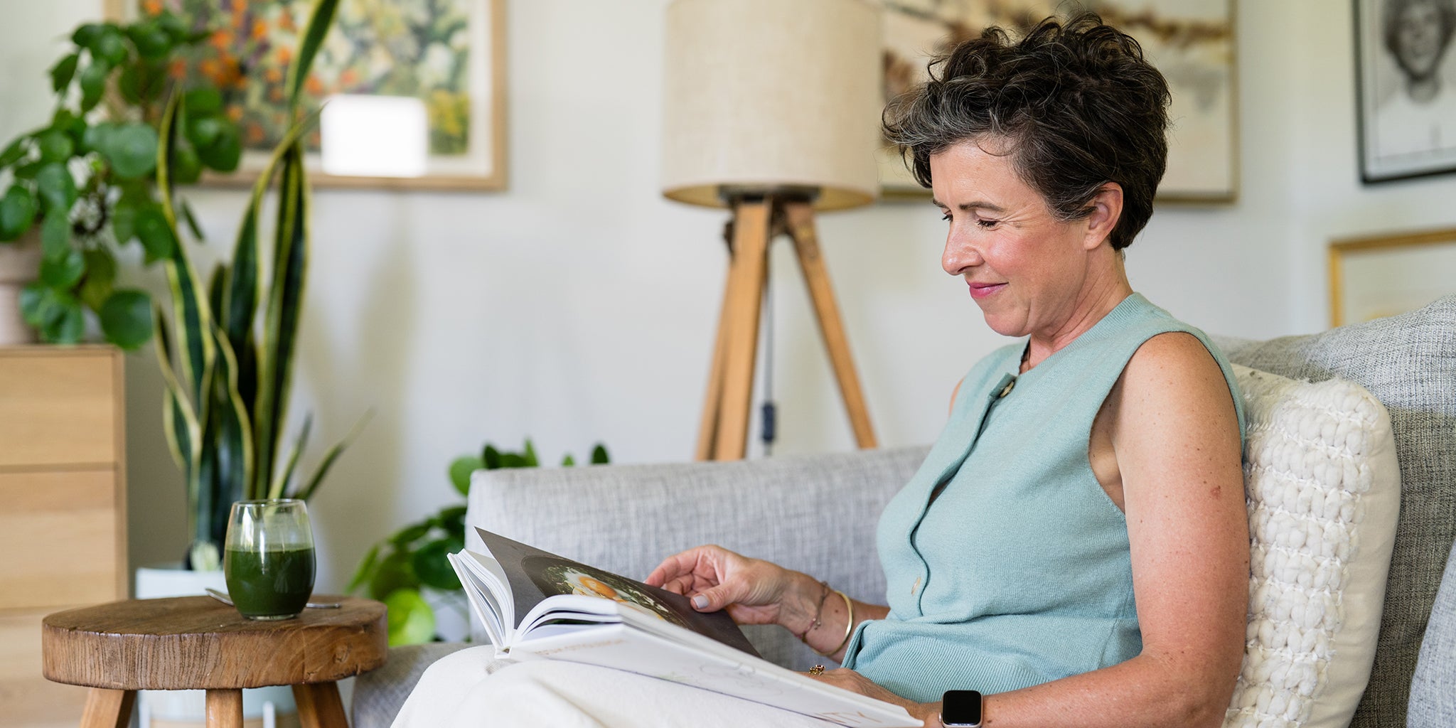 Amy reading a book on a couch in a cozy living room.
