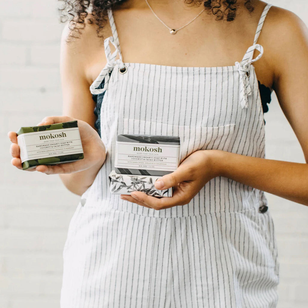 Someone holding  Mokosh handmade organic soaps.